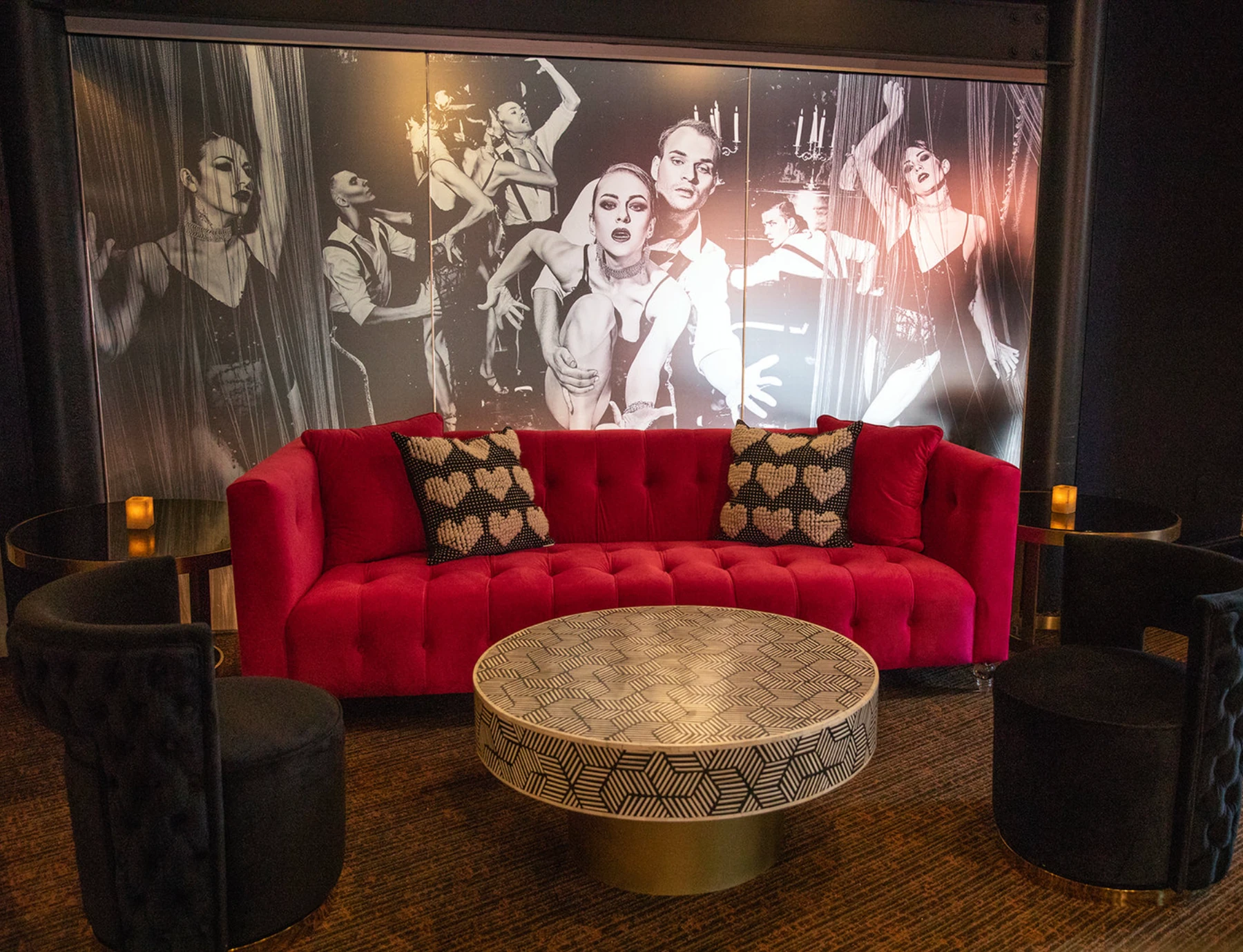 Venue interior design with a red velvet sofa and large black-and-white wall mural